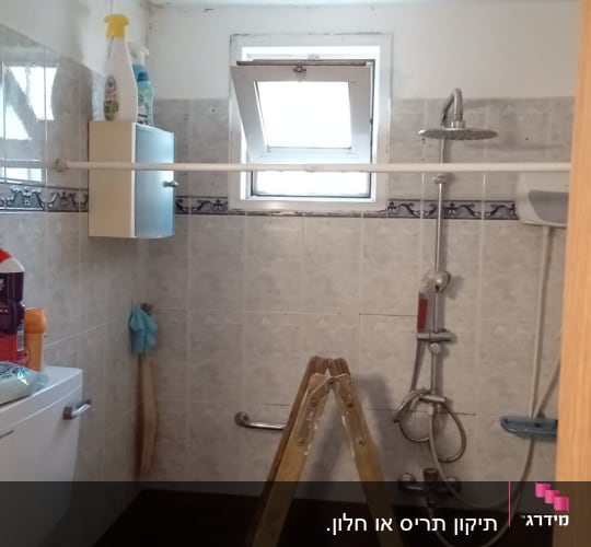 חלון עם תריסים פתוחים בחדר אמבטיה